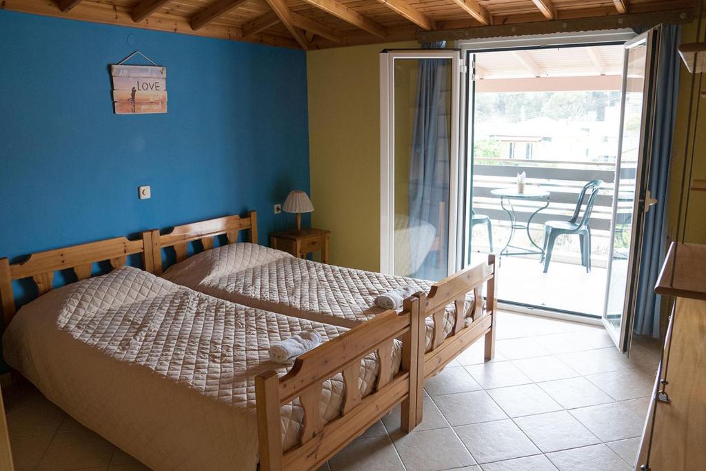 a bedroom with a bed and a balcony with a table at EFTIHIA in Kavos