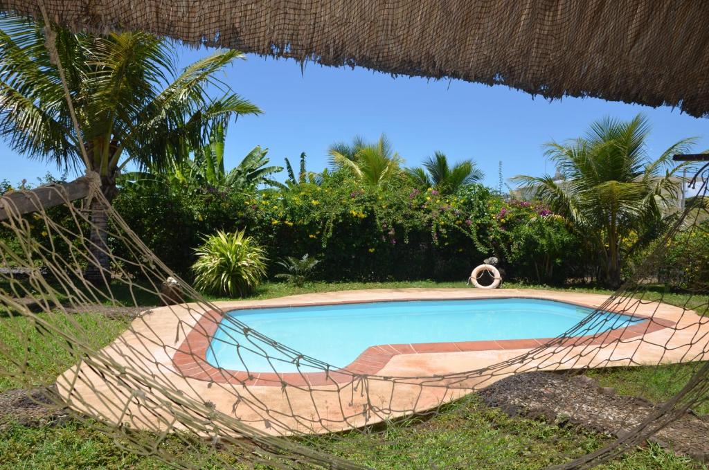 a hammock around a swimming pool in a resort at La Maison Soleil in Trou dʼ Eau Douce