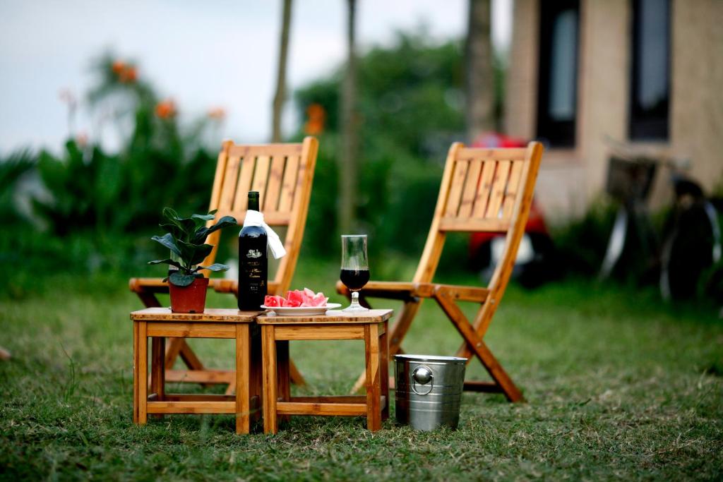 two chairs and a table with a bottle and a glass at May Homestay - Tam Coc Local Village in Ninh Binh