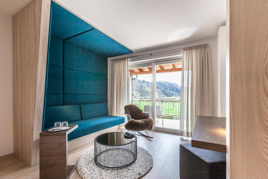 a living room with a blue couch and a table at Bollenhuthotel Kirnbacher Hof in Wolfach