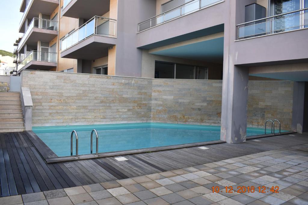 a swimming pool in front of a building at Quarportugal in São Martinho do Porto