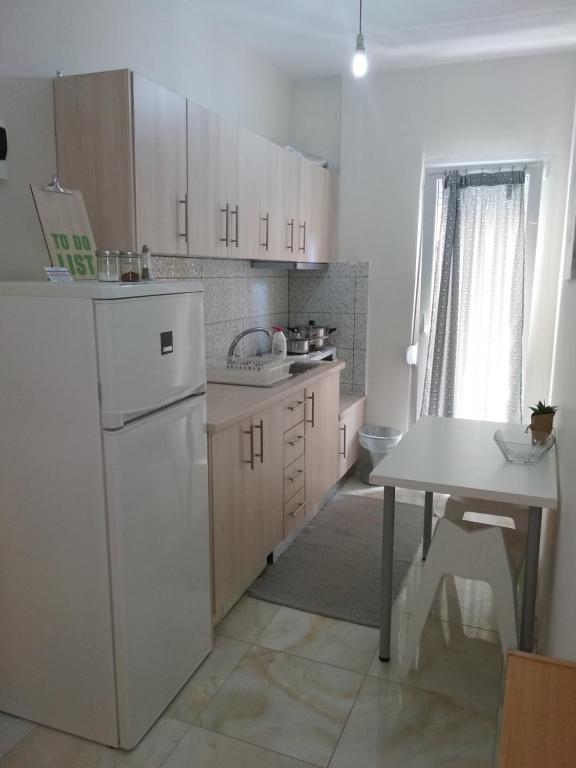 a kitchen with a white refrigerator and a table at Istos Apartment 4 in Thessaloniki