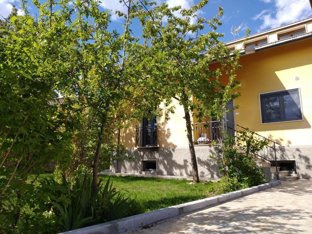 a house with trees in front of a yard at B&B A casa di Emy in Barisciano