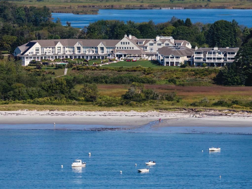 two boats in the water in front of a large house at Inn By the Sea in Cape Elizabeth