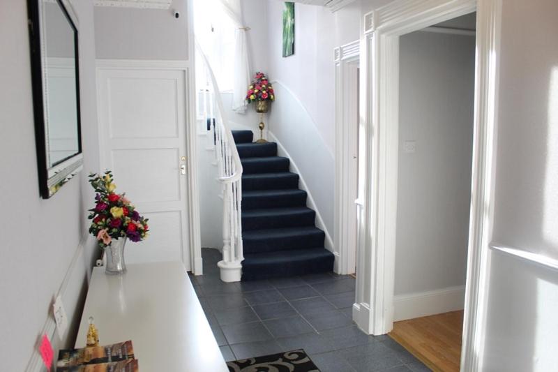 a hallway with a staircase with flowers in a room at Beautiful house on NC500 Route in Wick
