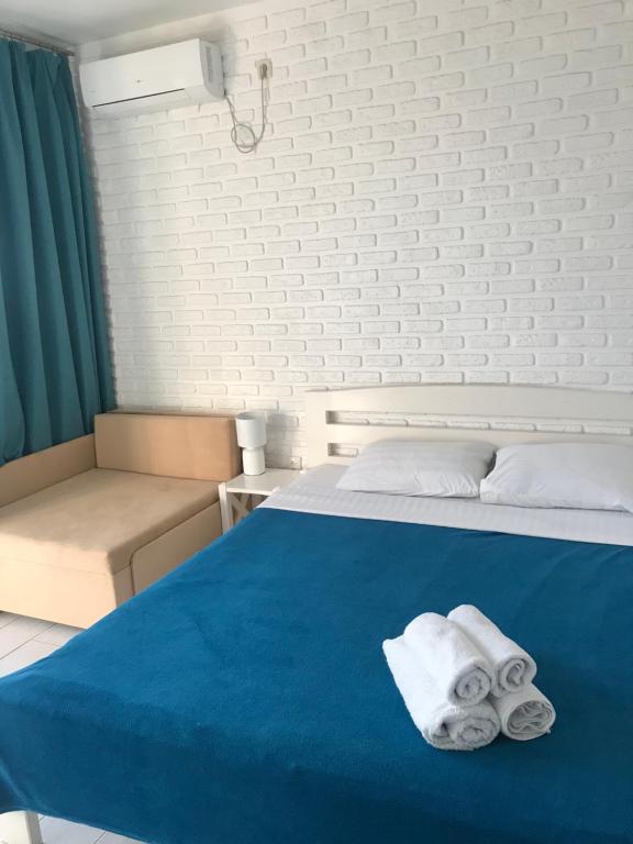 a bedroom with a blue bed with towels on it at Золотий ЛЕВ in Zatoka