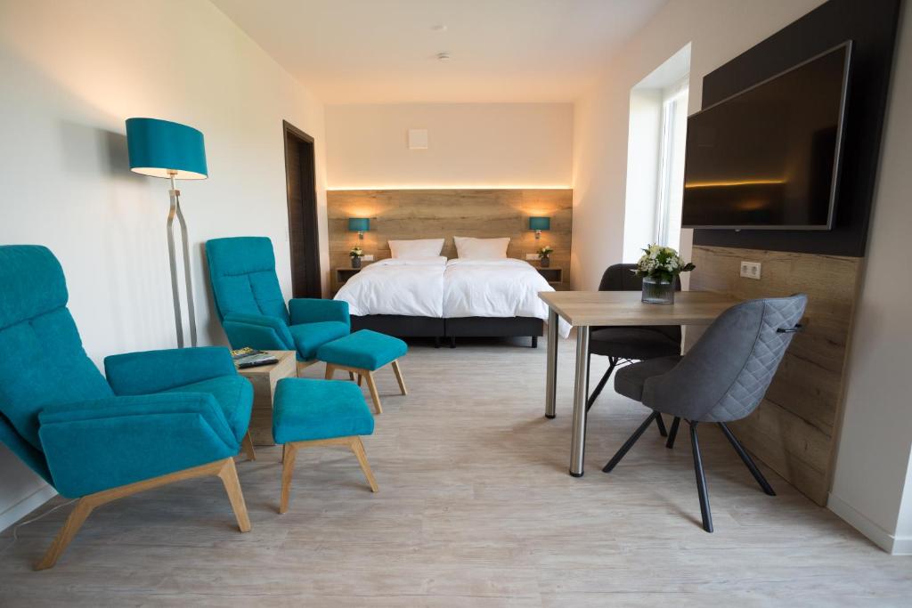 ディンクラーゲにある@home Boardinghouseのベッド、テーブル、椅子が備わるホテルルームです。
