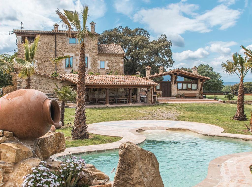 een uitzicht op een huis met een zwembad bij Mas Tulsà Casa Rural Girona in Riudellots de la Creu