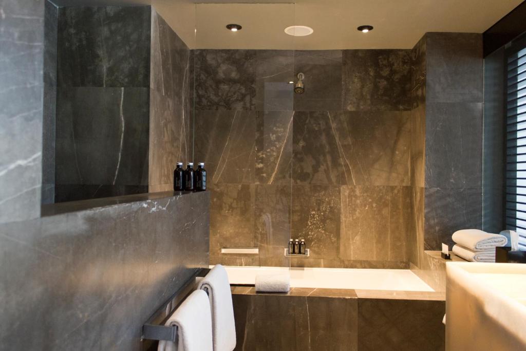 a bathroom with a bath tub and a sink at Habita Monterrey, a Member of Design Hotels in Monterrey