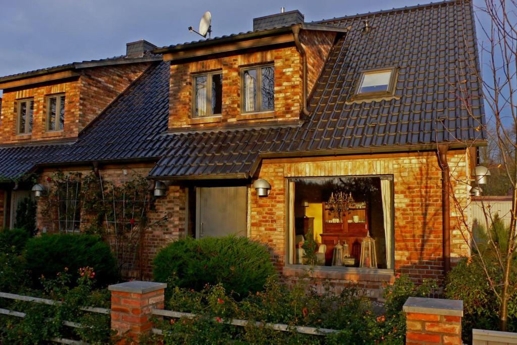 a brick house with a black roof at Große Ferienwohnung in Peetzig am See in Angermünde