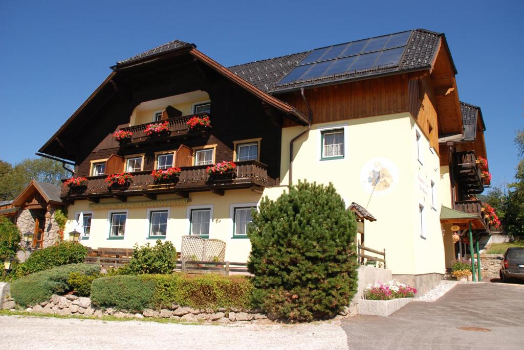 a house with a solar roof with flowers on the balcony at Hotel Zum Granitzl in Mariapfarr