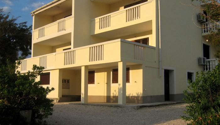 a large white building with balconies on it at Apartmani Presečki in Pag