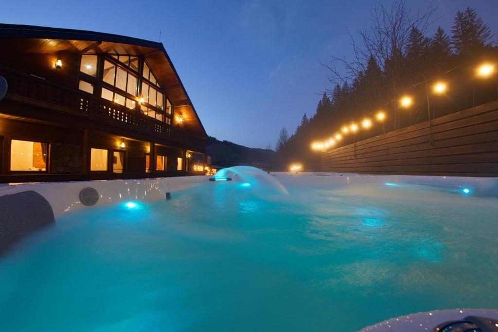 a large swimming pool with blue water at night at Bio Valeputna in Valea Putnei