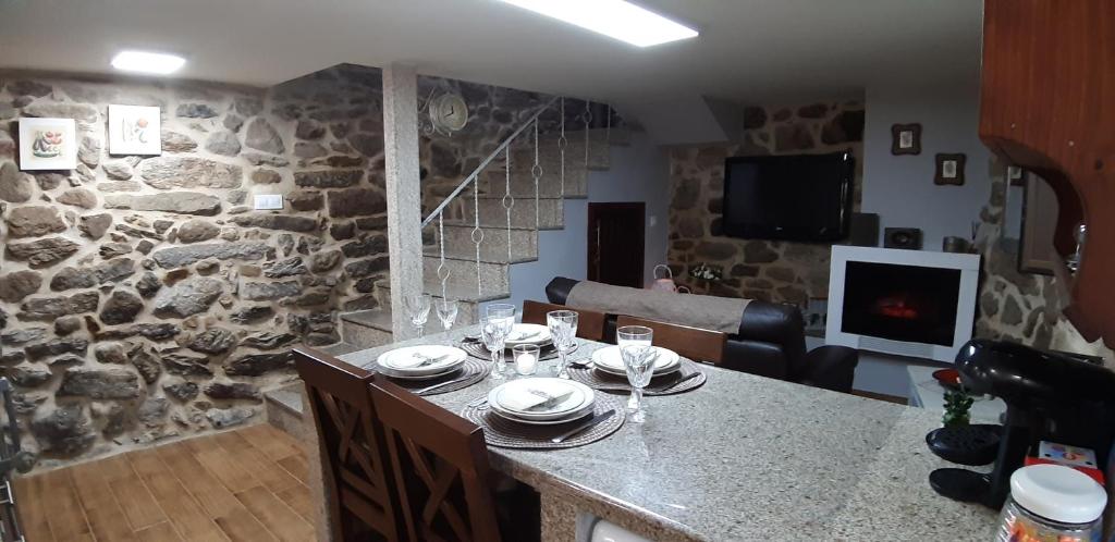 cocina con mesa y pared de piedra en A Casiña Vella, en Poio