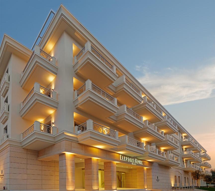 ein großes weißes Gebäude mit Balkonen darauf in der Unterkunft Elefsina Hotel in Eleusis