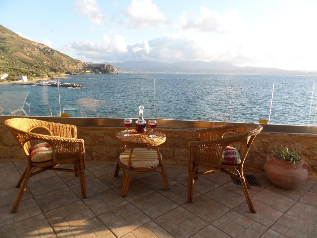 a table and chairs on a balcony overlooking the ocean at Endless Blue in Ravdhoúkha