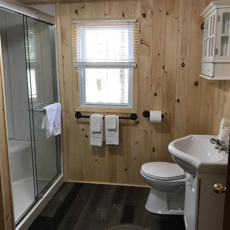 a bathroom with a toilet and a shower and a sink at Cloverleaf Cottages in Oxtongue Lake