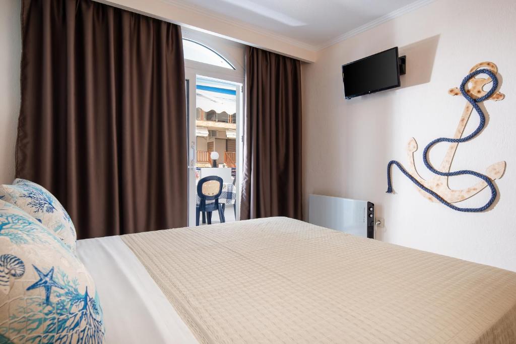 a hotel room with a bed and a television at House Katerina Mediterranean in Sarti