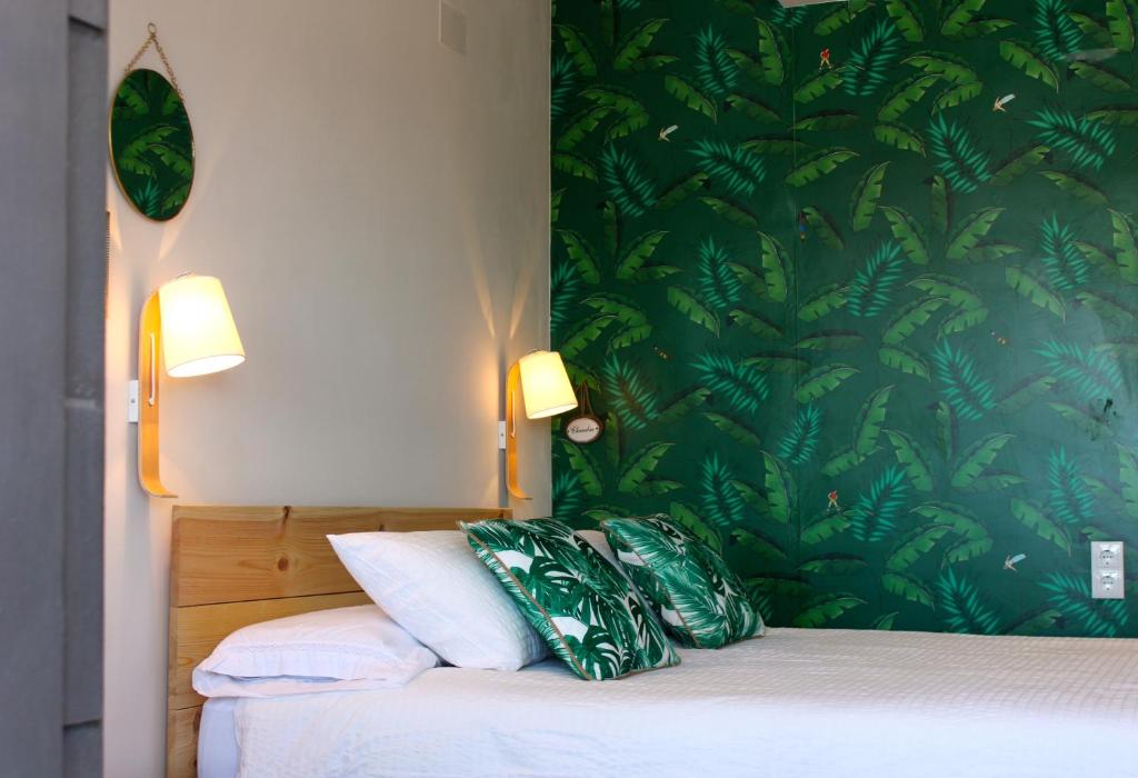 a bedroom with a bed with a green wallpaper at Nice Studio in Alicante City Centre in Alicante