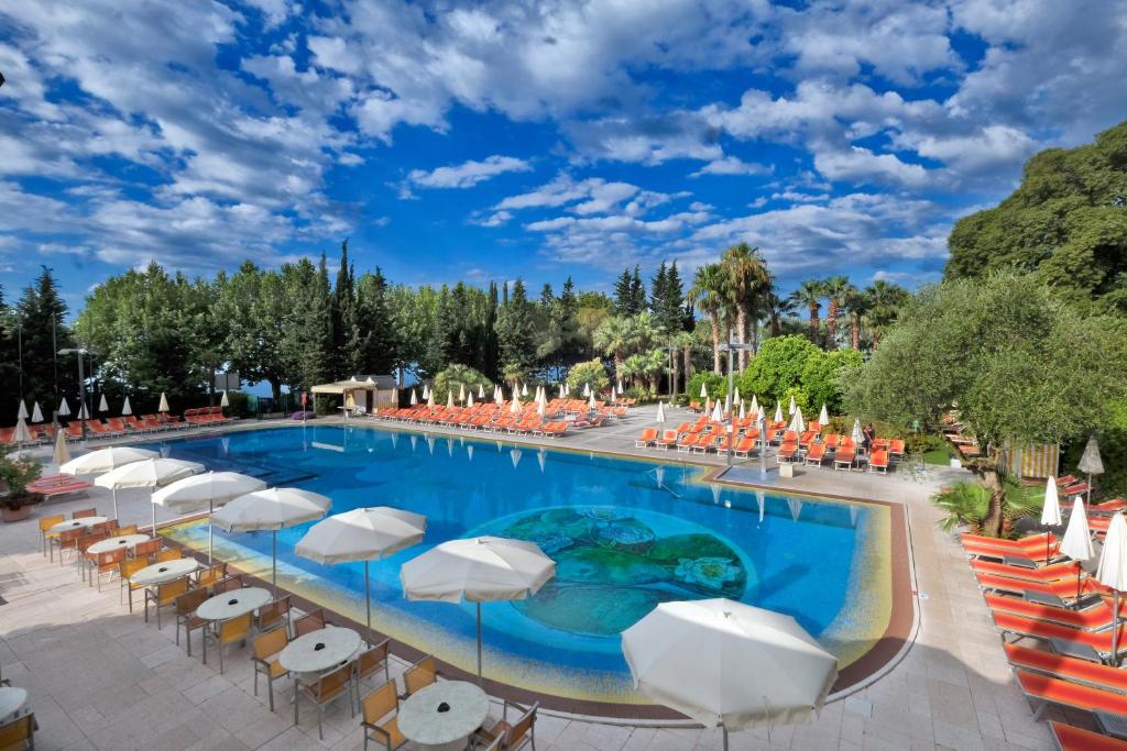 una grande piscina con sedie e ombrelloni di Parc Hotel Gritti a Bardolino