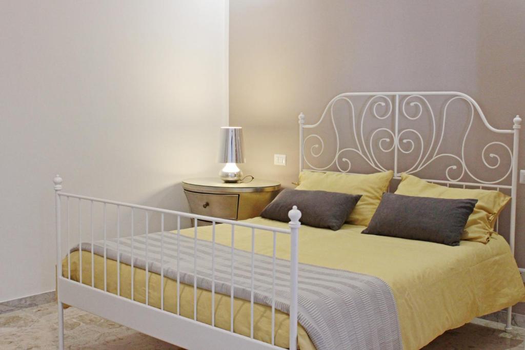 1 dormitorio con cama blanca y almohadas amarillas en I Tre Cardilli en Matera