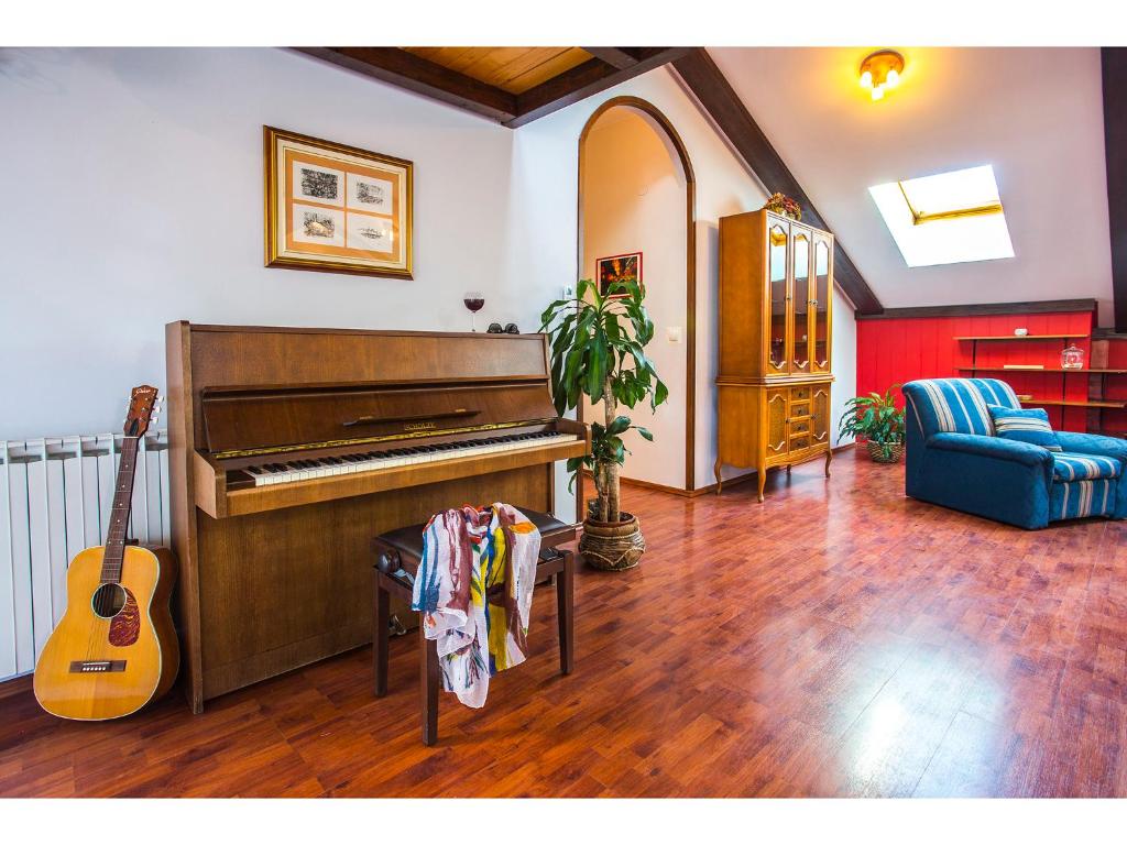 スプリトにあるRiva Royal Lounge Apartmentのピアノとギター付きのリビングルーム