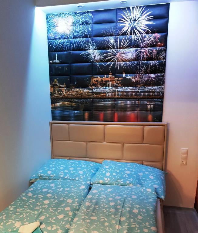 Hotel Fireworks Rakoczi mini, a bed in a room with a poster of fireworks at Fireworks Rakoczi mini in Budapest