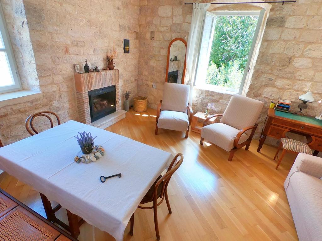 a living room with a table and a fireplace at Historic Piazza House & Romantic Hidden Garden in Hvar