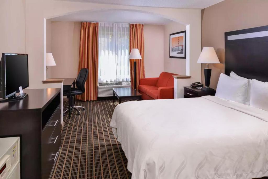 a hotel room with two beds and a television at Hotel Nova SFO By FairBridge in South San Francisco
