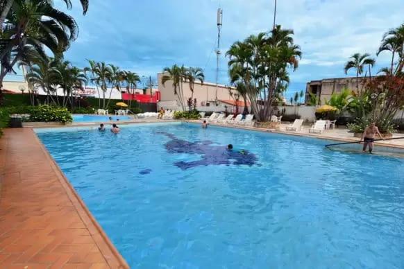 a swimming pool with people in the water at Acquaville Flat in Caldas Novas