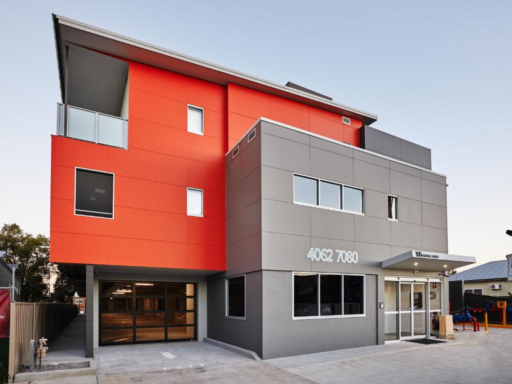 un grand bâtiment avec un rouge dans l'établissement East Maitland Executive Apartments, à Maitland