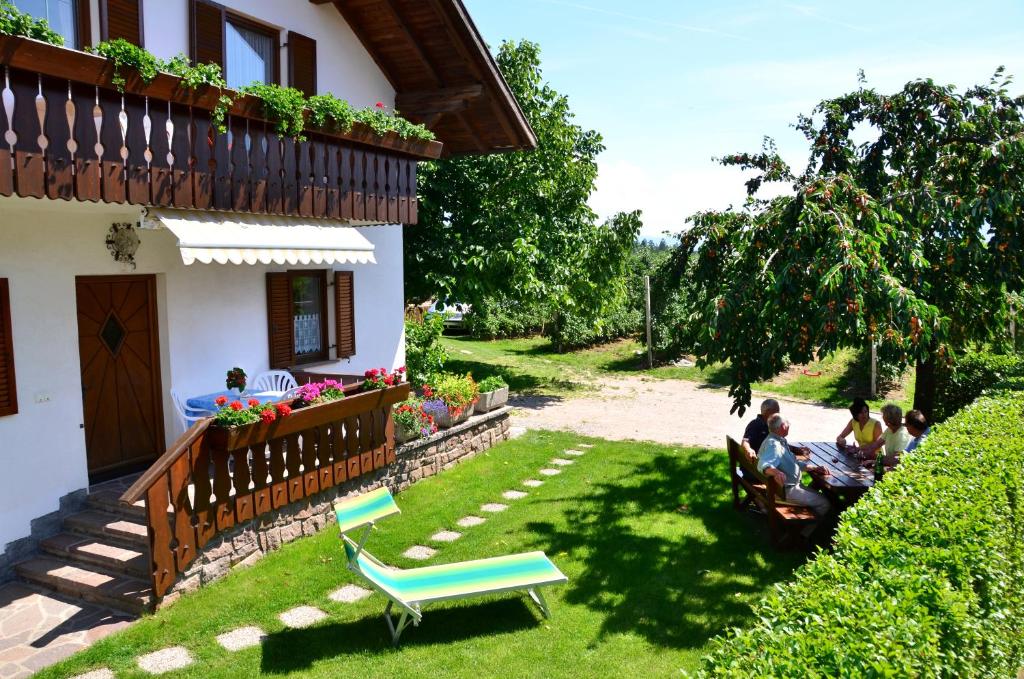 a group of people sitting in the yard of a house at Ferienwohnung Pippohof in Appiano sulla Strada del Vino