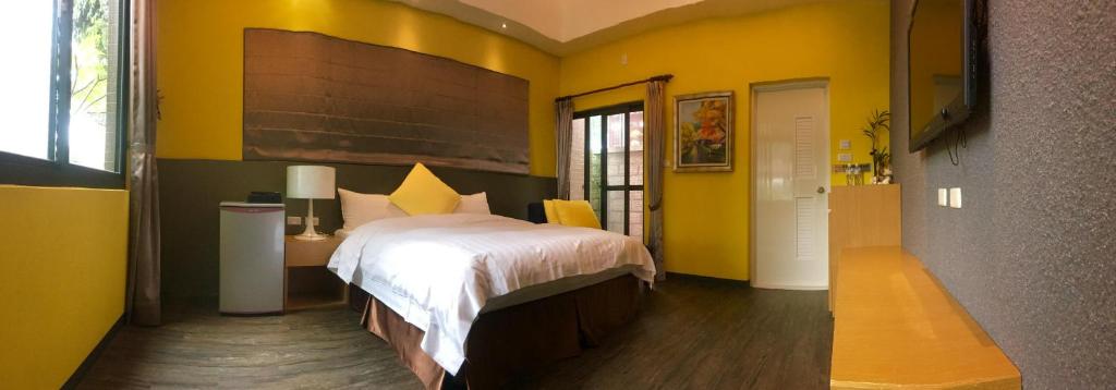 a bedroom with a bed in a yellow room at Great Nature Villa in Jiji