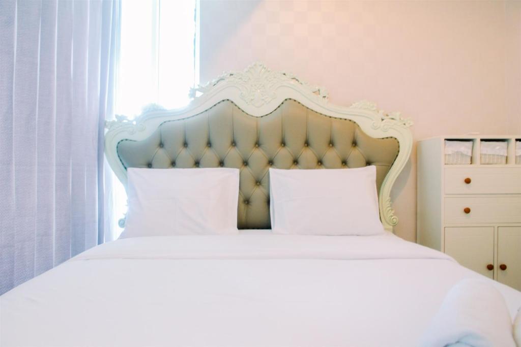a bedroom with a white bed with a blue headboard at Luxury Furnished 2BR Grand Kamala Lagoon Apartment By Travelio in Pulosirih