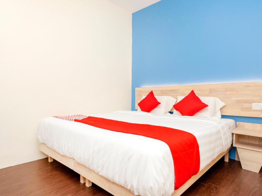1 dormitorio con 1 cama grande con almohadas rojas en OYO 778 Bmw 2 Hotel, en Muar
