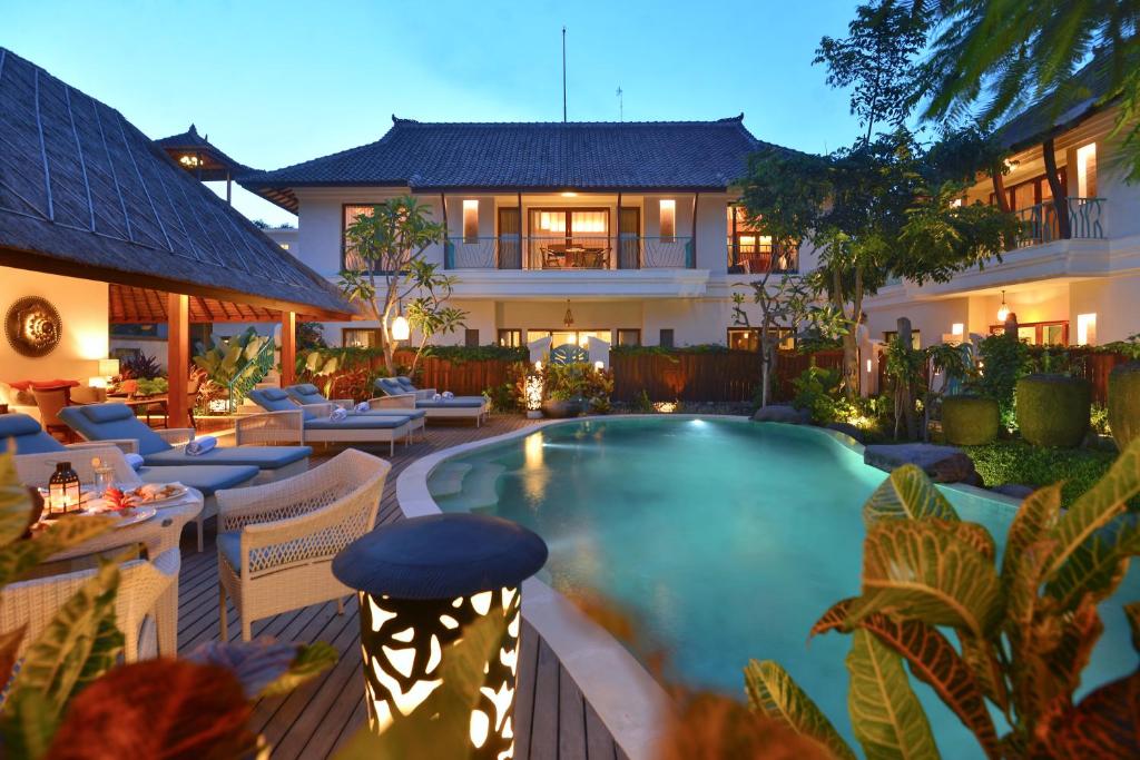 a hotel with a swimming pool in front of a building at Kama Village by Nakula in Sanur