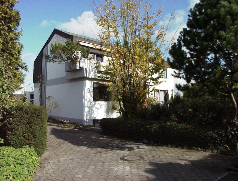 ein weißes Haus mit einem Baum davor in der Unterkunft BodenSEE Apartment Langenargen Fliederweg in Langenargen