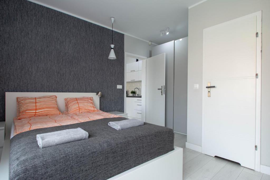 ウェバにあるOaza Łeba - Pokoje w centrum Łebyのベッドルーム1室(大型ベッド1台、オレンジ色の枕付)