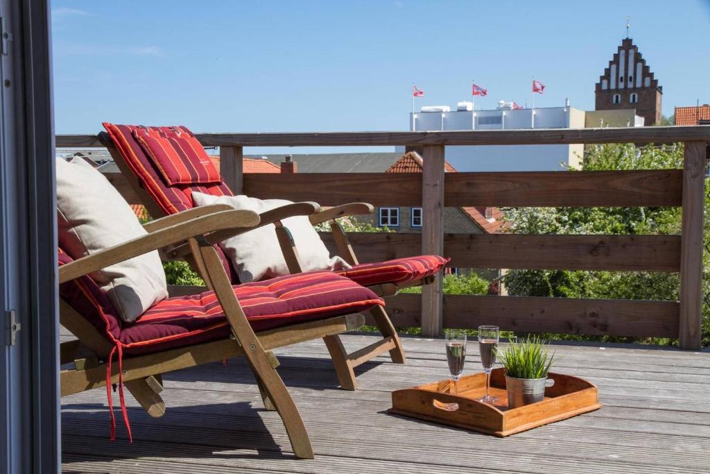 a rocking chair sitting on a deck with a table at moevDECK in Heiligenhafen