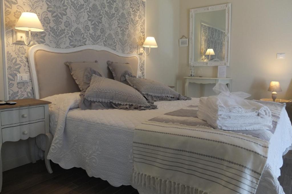 um quarto com uma cama branca e um espelho em Romantic Home em Sirmione