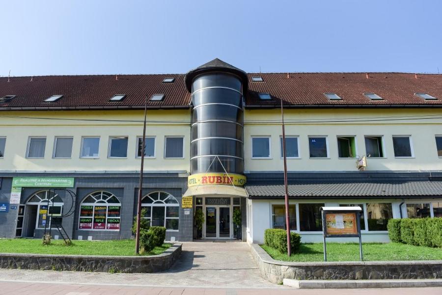 a large white building with a black pipe at Hotel Rubín in Svidník