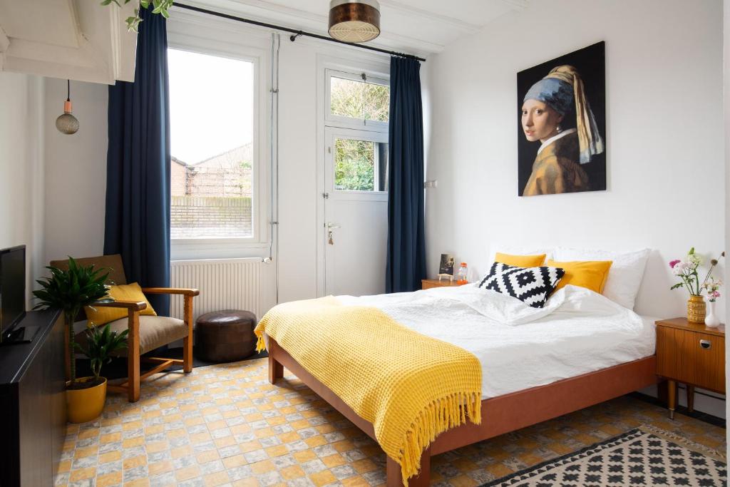 een slaapkamer met een bed en een schilderij aan de muur bij B&B d'Ouwe Grutter in Wagenberg