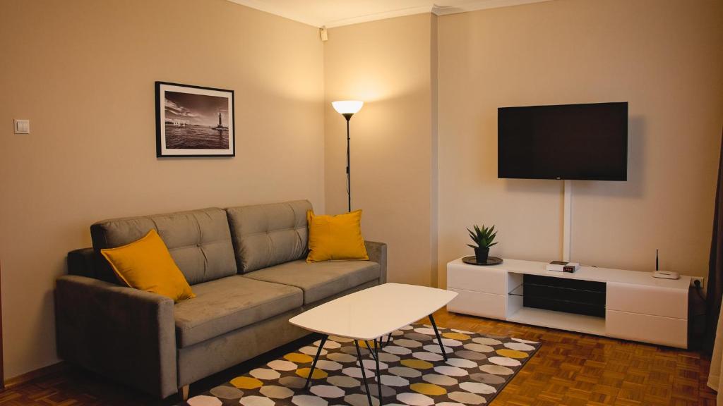 a living room with a couch and a flat screen tv at Mieszkanie przy Rynku in Racibórz