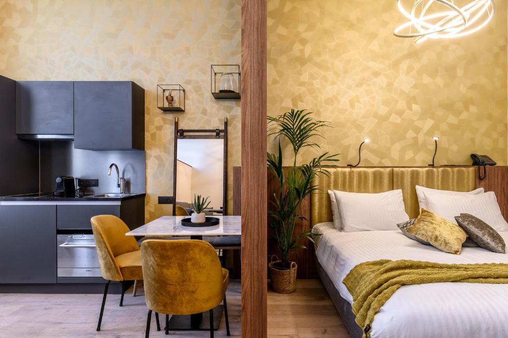 1 dormitorio con cama, mesa y cocina en Leopold Hotel Oudenaarde, en Oudenaarde