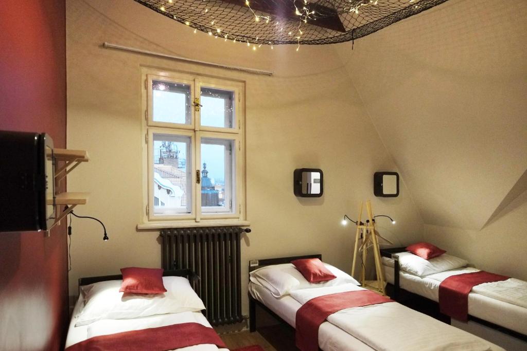 a room with three beds and a window at Czech Inn in Prague