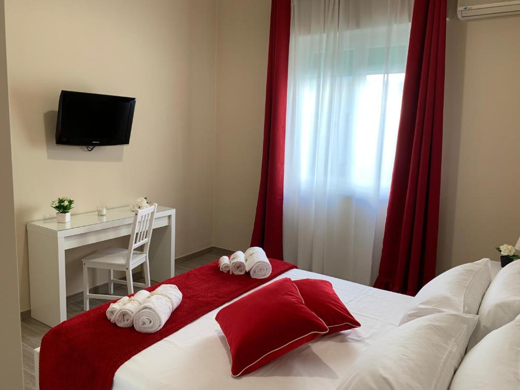 a bedroom with a bed with red curtains and a desk at Casa Al Porto in Palermo