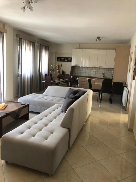 a large living room with a couch and a kitchen at Casa Ideale in Limenaria