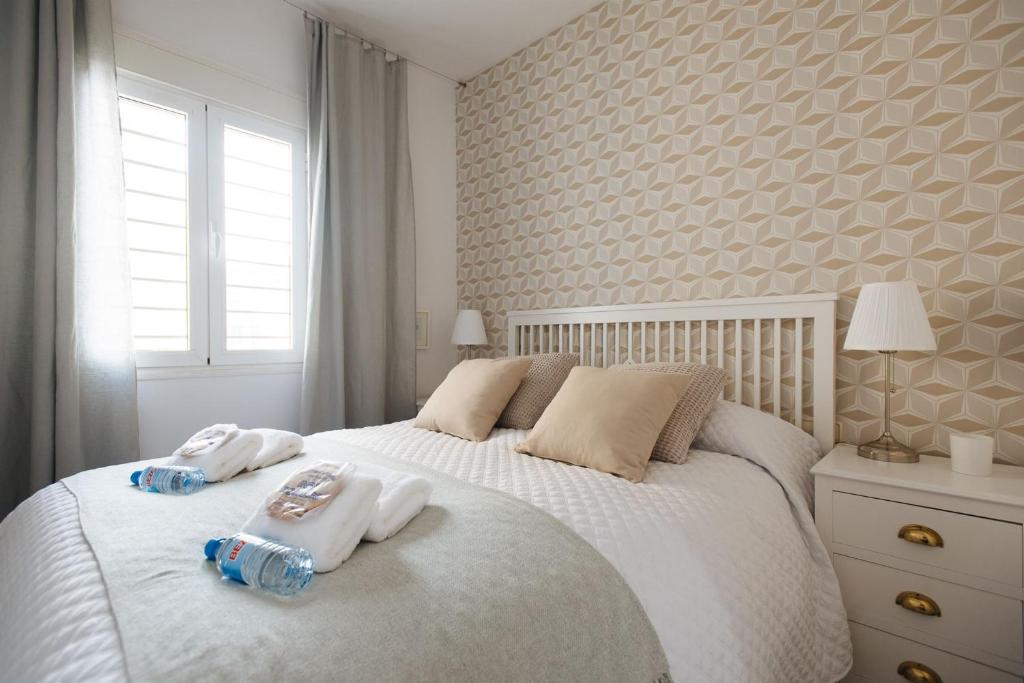 a bedroom with two towels on a white bed at El Refugio de San Luis con parking opcional in Seville