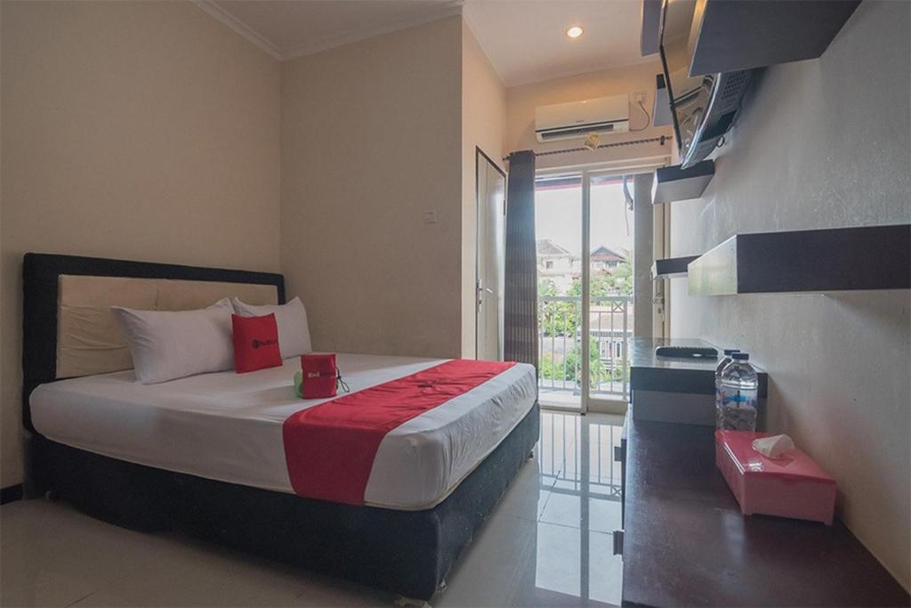a bedroom with a bed and a large window at RedDoorz near E Walk Mall Balikpapan in Balikpapan