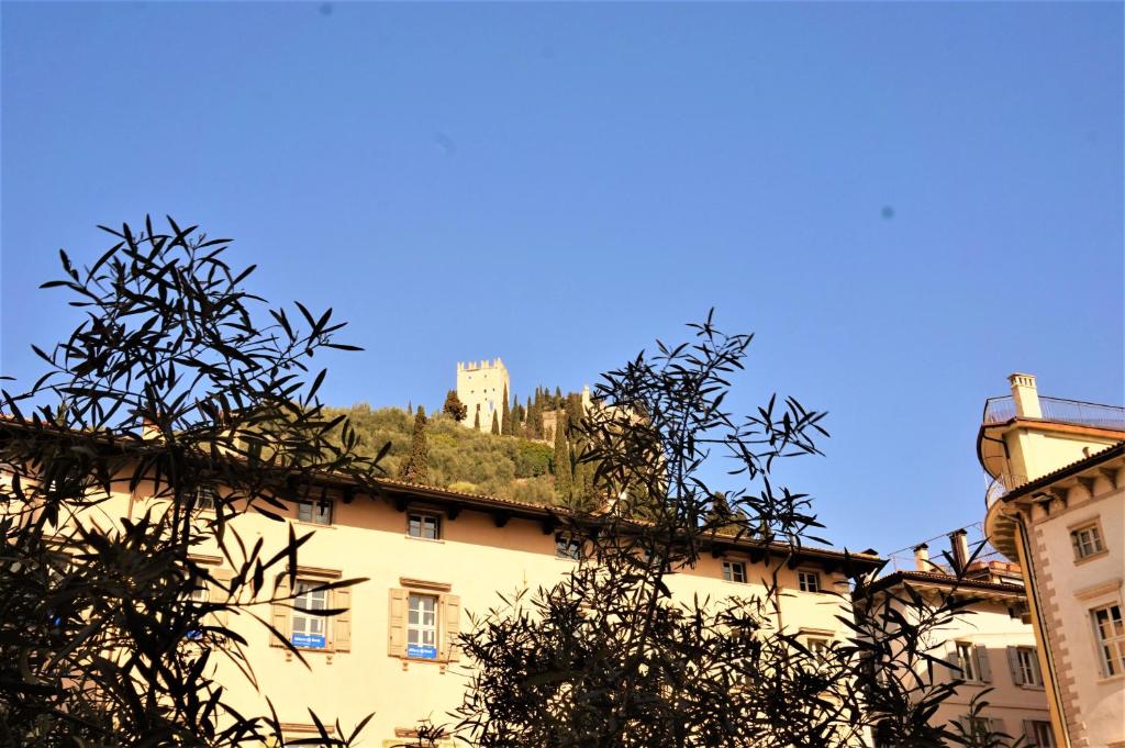 un bâtiment avec un château au sommet d'une colline dans l'établissement Residenza Castello, à Arco